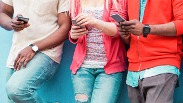 3 young people looking at their phones